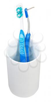one tooth brush and interdental brush in ceramic glass isolated on white background