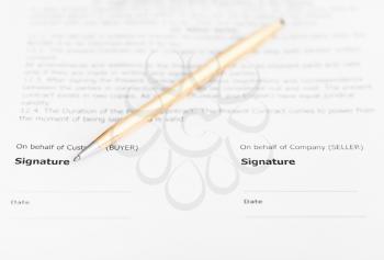 golden pen on signature page of sales agreement