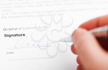 customer signing sales contract by silver pen close up