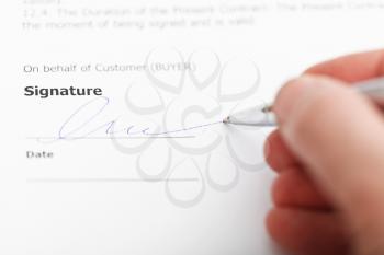 customer signing sales agreement by silver pen close up