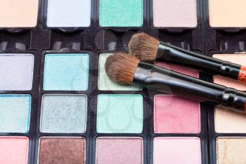 makeup kit and cosmetic brushes close up