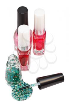 nail polish bottles and spilled green lacquer isolated on white
