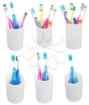 collection of toothbrushes in ceramic glases isolated on white background