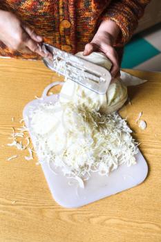 woman chopping cabbage by manual slaw cutter on table