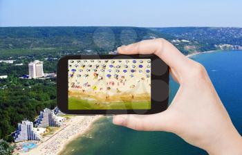 travel concept - tourist taking photo of Albena sand beach on mobile gadget, Bulgaria