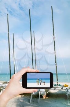 travel concept - tourist taking photo of Atlantic ocean coast in Varadero on mobile gadget, Cuba