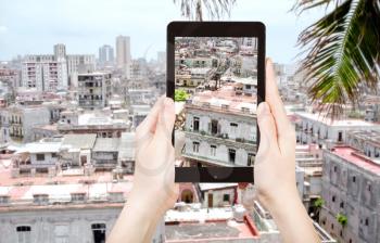 travel concept - tourist taking photo of houses in old Havana city on mobile gadget, Cuba
