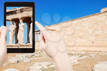 travel concept - tourist taking photo of caryatids at acropolis on mobile gadget, Athens, Greece