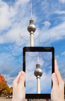 travel concept - tourist taking photo of TV tower on alexanderplatz on mobile gadget, Berlin, Germany