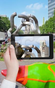travel concept - tourist taking photo of Berlin symbols in charlottenburg district on mobile gadget, Germany