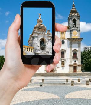 travel concept - tourist taking photo of The Igreja do Carmo (Carmo Church) in Faro, Portugal on mobile gadget