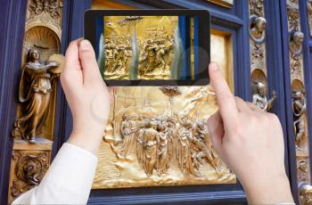 travel concept - tourist taking photo of east gate of Baptistery in Florence on mobile gadget, Italy