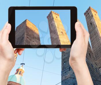 travel concept - tourist taking photo Due Torri Two Towers in Bologna city of on mobile gadget, Italy