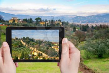 travel concept - tourist taking photo of green hills in Tuscany on mobile gadget, Florence, Italy