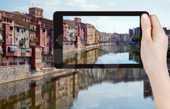 travel concept - tourist taking photo of river in Girona town on mobile gadget, Spain