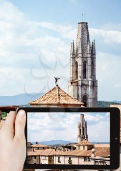 travel concept - tourist taking photo of Collegiate Church of Sant Feliu on mobile gadget