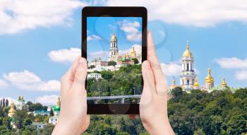 travel concept - tourist taking photo of Kiev Pechersk Lavra, Kiev, Ukraine on mobile gadget