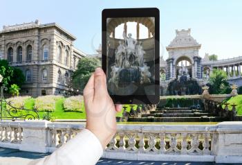 travel concept - tourist taking photo of fountain in Palais de Longchamp, Marseilles, France on mobile gadget