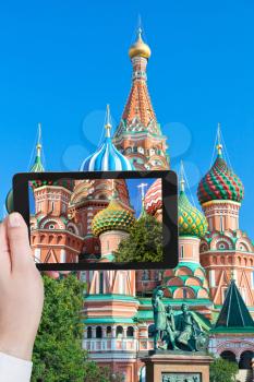 travel concept - tourist taking photo of colors towers of Saint Basil cathedral on Red Square in Moscow on mobile gadget, Russia