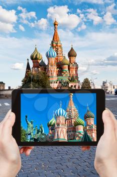 travel concept - tourist taking photo of Pokrovsky cathedral on Red square in Moscow on mobile gadget, Russia