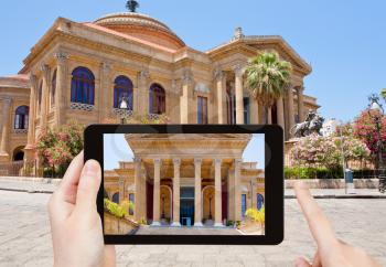 travel concept - tourist taking photo of Teatro Massimo - famous opera house in Palermo, Sicily on mobile gadget, Italy