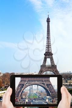 travel concept - tourist taking photo of Champ de Mars, Pont d Iena and Eiffel Tower in Paris on mobile gadget, France