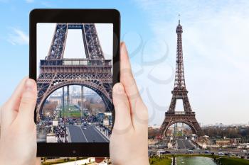travel concept - tourist taking photo of Champ de Mars and Eiffel Tower from Trocadero in Paris on mobile gadget, France