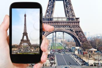 travel concept - tourist taking photo of Eiffel tower in Paris from Trocadero on mobile gadget, France