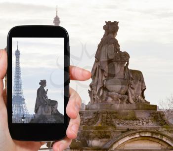 travel concept - tourist taking photo of statue Marseille, column on place de la Concorde and Eiffel Tower in Paris at sunset on mobile gadget, France