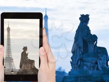 travel concept - tourist taking photo of statue Marseille on place de la Concorde and Eiffel Tower in Paris at sunset on mobile gadget, France
