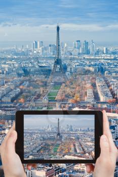 travel concept - tourist taking photo of Eiffel Tower and panorama of Paris afternoon on mobile gadget, France