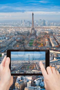 travel concept - tourist taking photo of Eiffel Tower and Field of Mars in Paris on mobile gadget, France