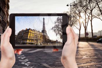 travel concept - tourist taking photo of Quay Branly in Paris on sunset on mobile gadget, France
