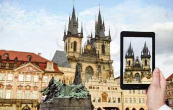 travel concept - tourist taking photo of Church of Our Lady before Tyn in Prague on mobile gadget, Czech
