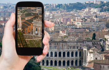 travel concept - tourist taking photo of Theatre Marcellus in old center of Rome on mobile gadget, Italy