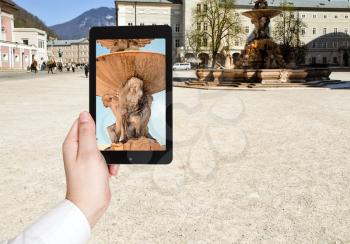 travel concept - tourist taking photo of fountain in Salzburg on mobile gadget, Austria