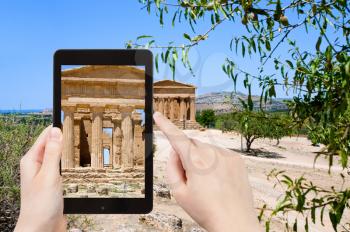 travel concept - tourist taking photo of ancient Temple of Concordia in Valley of the Temples, Agrigento, Sicilyon mobile gadget