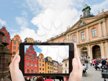 travel concept - tourist taking photo of medieval Stortorget square in Stockholm on mobile gadget, Sweden