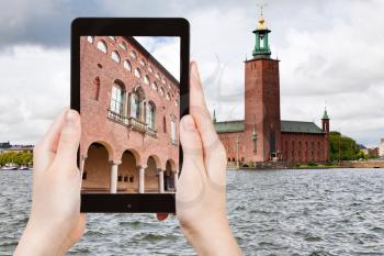 travel concept - tourist taking photo of Stockholm City Hall, Sweden on mobile gadget