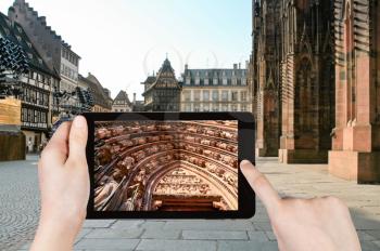 travel concept - tourist taking photo of cathedral in Strasbourg, France on mobile gadget