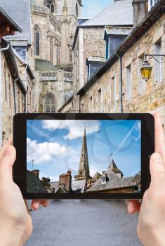 travel concept - tourist taking photo of Cathedral in Treguier town on mobile gadget, Brittany, France