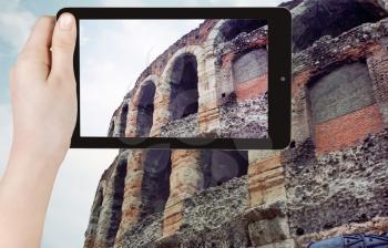 travel concept - tourist taking photo of ancient roman arena in Verona on mobile gadget, Italy