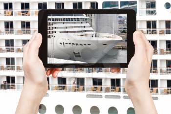 travel concept - tourist takes picture of big cruise liner on smartphone,