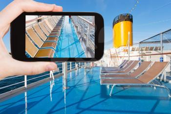 travel concept - tourist shoot photo of sunbath chairs on upper deck of cruise liner on smartphone,