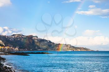 view of Giardini Naxos resort, Taormina cape and rainbow in Ionian Sea in spring, Sicily