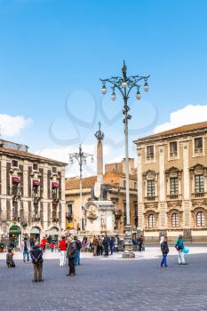 CATANIA, ITALY - APRIL 5, 2015: people on Piazza del Duomo and U Liotru (Fontana dell ' Elefante) - symbol of Catania, Sicily, Italy. The fountain was assembled in 1736 by Giovanni Battista Vaccarini.