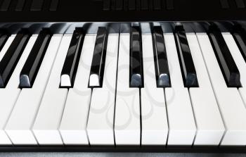 front view of black and white keys of musical digital keyboard close up