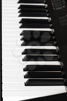 side view of black and white keys of digital piano close up