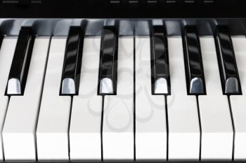 front view of black and white keys of digital piano close up