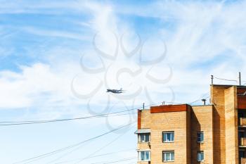 transport aircraft in blue sky over urban house